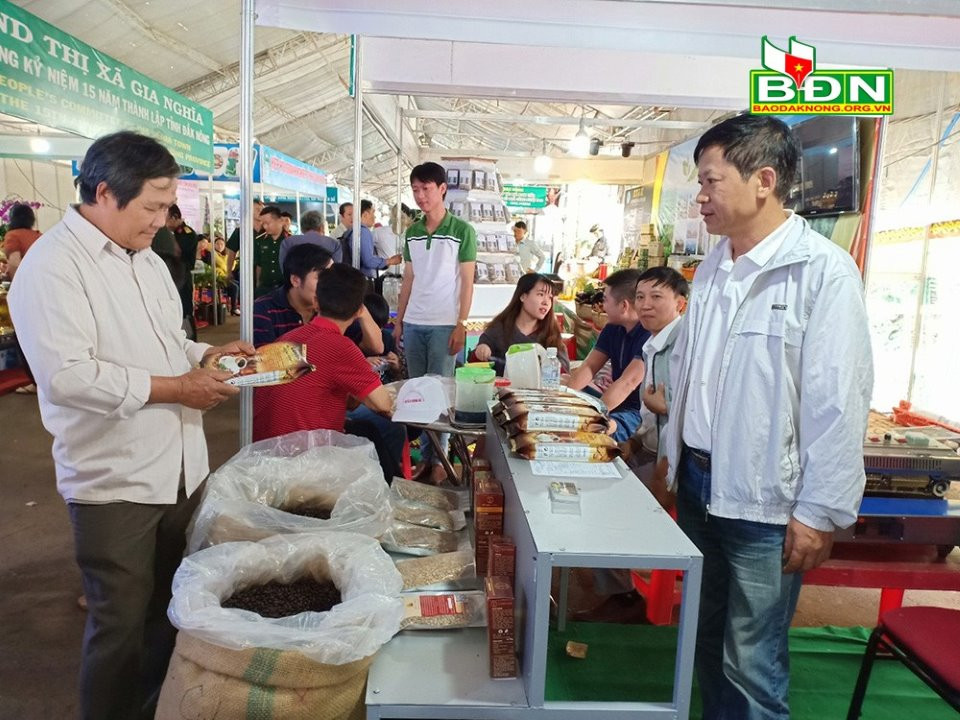 Ông Hồ Trọng Tín, Giám đốc HTX Tín true coffe (bên phải) giới thiệu sản phẩm cà phê của HTX tại Hội chợ xúc tiến đầu tư tỉnh Đắk Nông
